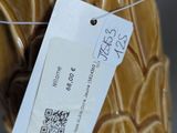 a brown vase with a tag on it and a tag attached to it