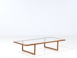 a coffee table with a glass top and wooden legs