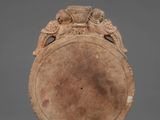 an old brown vase with a bird decoration on the top of it