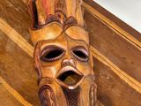 un masque en bois posé sur une table en bois