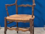 une chaise en bois avec une assise marron et un mur bleu en arrière-plan