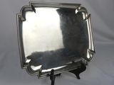 an antique silver plate with a black stand on a white background