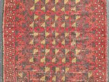 a red and brown rug with a geometric design on it