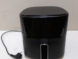 une photo d'un grille-pain noir posé sur une table blanche