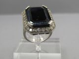an image of a ring with a black stone surrounded by white diamonds