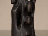 une photo représentant une sculpture noire posée sur une table en verre