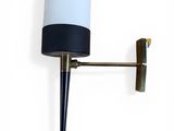 the wall lamp is mounted on the wall with a black and white shade