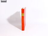un livre rouge posé sur une surface blanche