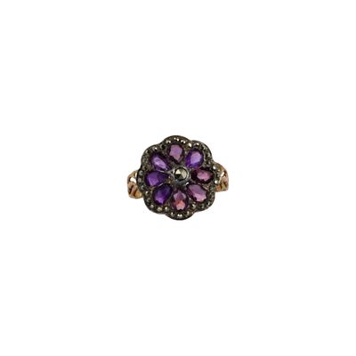 un gros plan d'une bague sertie d'un diamant violet et noir sur fond blanc
