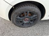 a white car with a black rim and a red circle on it