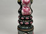 a black and pink vase sitting on top of a white table