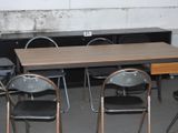 une table et des chaises dans une pièce, avec un mur derrière elles