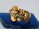 une image représentant une bague en or posée sur un morceau de roche bleue