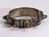 silver bracelet with coral and silver beads on a white surface