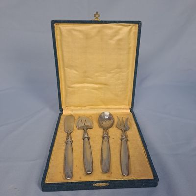 quatre fourchettes et un couteau dans un étui posé sur une table