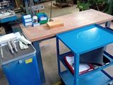 une table avec un plateau bleu et un chariot bleu contenant des outils