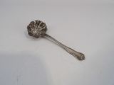 a silver spoon with a flower on it on a white surface