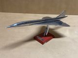 une maquette d'avion en argent posée sur un socle rouge