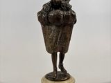 bronze statue of a woman holding a basket on a marble base