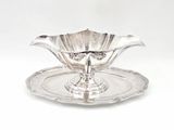 a silver plate with a flower on it on a white background