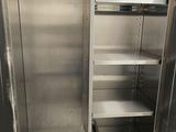 a stainless steel cabinet with shelves in the middle of the room