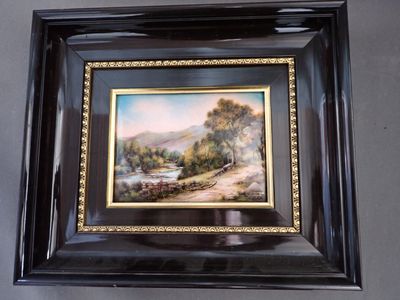 framed picture of a painting of a landscape with a river running through it