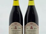 deux bouteilles de vin posées sur une table l'une à côté de l'autre