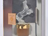 packaging of a perfume bottle in a box with a horse figurine in it