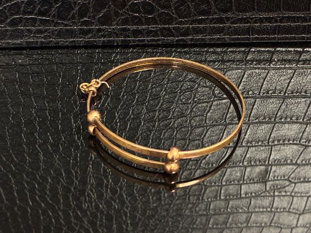 Bracelet rigide en métal doré. Frais en sus : 10% HT soit 12% TTC