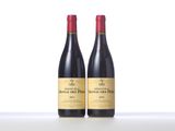 two bottles of red wine sitting on top of a table