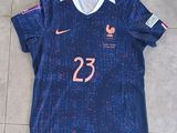 Le maillot est bleu et porte le numéro 23 en rose.