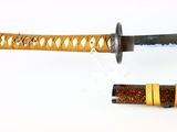 a close up of a knife with a gold band on it