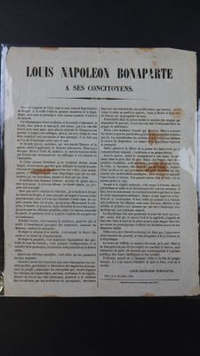un vieux journal posé sur une table, à côté d'un verre de vin