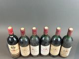six bottles of wine lined up in a row on a table