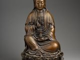 a bronze figure of a buddha sitting on a lotus flower