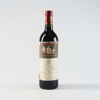 une bouteille de vin rouge posée sur une table blanche