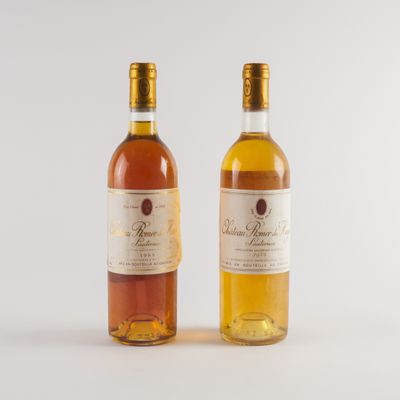 deux bouteilles de vin posées l'une à côté de l'autre sur une surface blanche