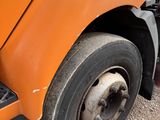 a close up of a flat tire on an orange truck