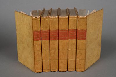 four books are stacked on top of each other on a gray surface