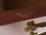 a close up of a clock on a wooden shelf