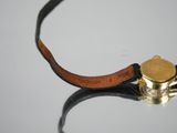 a close up of a watch with a leather strap