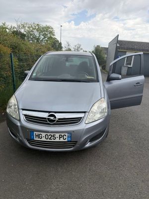 La voiture est garée sur le bord de la route, près d'une clôture