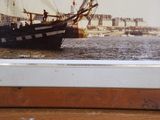 a picture of a boat in the water with a bridge in the background