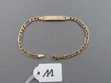un gros plan d'un bracelet en or auquel est attachée une étiquette