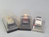 three toy cars in a display case on a table