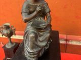 une statue de femme assise sur une table