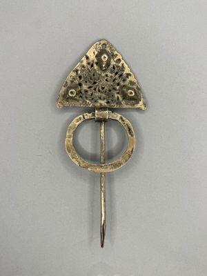 an image of a gold broochle with a triangle on top of it