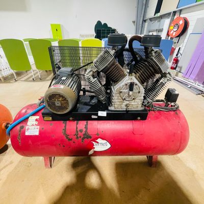 a red air compressor sitting on top of a red tank