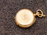 une montre de poche en or à laquelle est attachée une chaîne