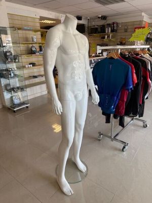 un mannequin masculin dans un magasin où sont exposées de nombreuses chemises